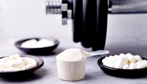 Beta-alanine Beta-alanine supplements in powder and capsule form placed beside a dumbbell, highlighting fitness and muscle performance support.