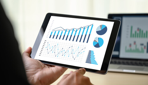 Person analyzing charts and graphs on a tablet, representing types of agile methodology and project management insights. Types of agile methodology