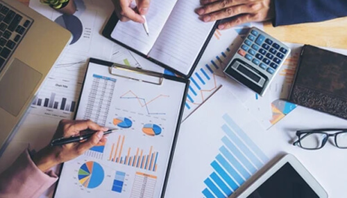 Chart accounts Team analyzing charts, graphs, and financial data on a desk, highlighting business accounting and performance reporting activities.