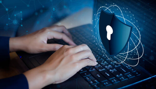 Data security Hands typing on a laptop with a digital shield and lock icon overlay, representing mdm-based data security for protecting and managing sensitive mobile device information.