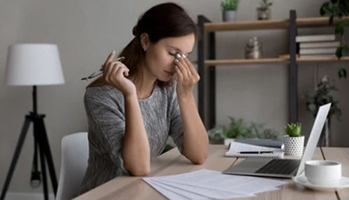 Stressed employee experiencing burnout and disengagement, highlighting the importance of defending against insider threats in the workplace. Defending against insider threats