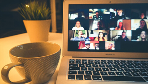 Laptop showing a video call with multiple participants, representing calendar and booking software for remote collaboration. Calendar and booking software