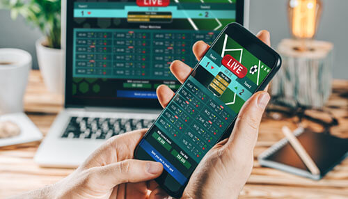 Betting types A person’s hand holds a smartphone that has a translucent soccer ball emerging from the screen, set against a deep blue background with the text "sbobet" highlighted on the right. This represents the immersive digital experience provided by modern sports betting platforms.