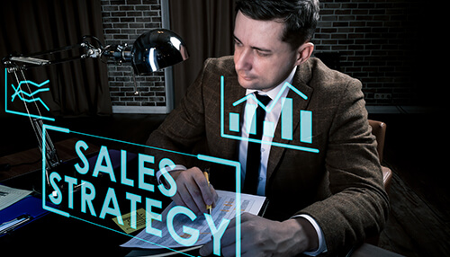 Constantly tests your sales strategies - tycoonstory | tycoonstory media A person pointng pen in paper he represents blue color sales strategy in a box and graph, analytics.