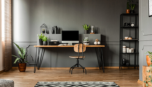 Remote work Minimalistic home office setup with a wooden desk, computer, and plants in a modern space, perfect for it remote work.