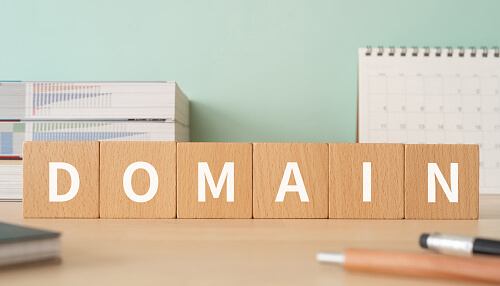 Domain name The word domain spelled out with wooden blocks, symbolizing the importance of choosing the right domain when shifting an offline business to an online platform.