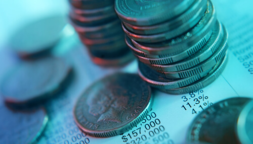 Fixed costs Stacks of coins on financial documents, symbolizing the allocation and management of funds within a startup budget for growth and development.