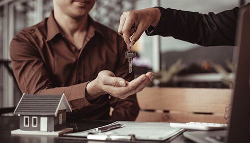 Entrepreneurs park their capital Entrepreneurs park their capital as a business professional hands over property keys across a desk, symbolizing strategic investment and asset ownership