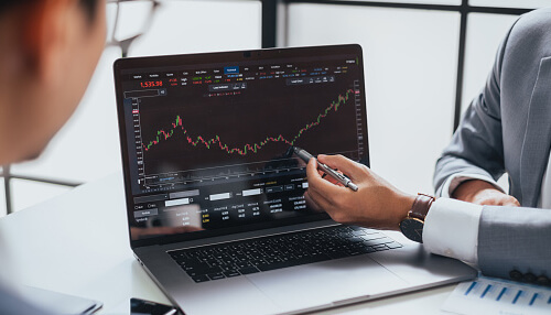 Bitcoin trading in sweden's Economy Business professionals analyzing bitcoin trading data on a laptop, emphasizing the role of bitcoin in sweden's economic landscape.