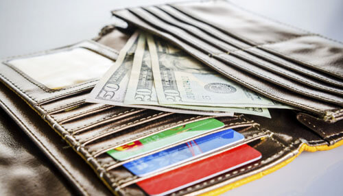 Credit reward card Wallet filled with multiple credit reward cards and cash, showcasing reward programs and card benefits.