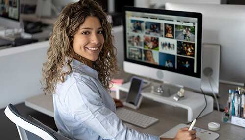 Choose images based on quality - tycoonstory | tycoonstory media A woman editing photos on a desktop computer, illustrating the importance of great images for your website to enhance visual appeal and user engagement.