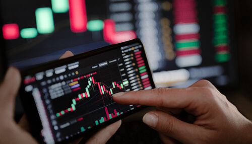Copy trading as a practical component of social trading A person using a smartphone to analyze a trading chart, demonstrating the concept of copy trading as part of social trading.