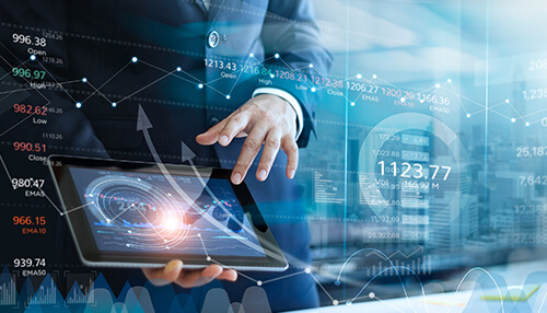 Data collection methods A business professional using a tablet with digital data visualizations, highlighting the role of data collection in business analytics for informed decision-making.