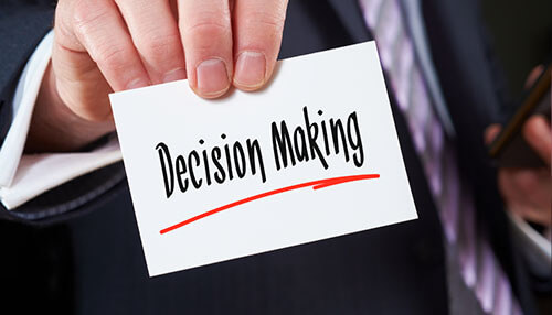 Decision making - tycoonstory | tycoonstory media Business professional holding a card with the words'Decision Making' symbolizing a client-centric approach to decision-making.