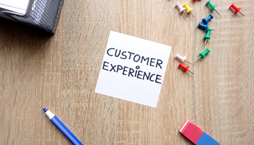 Direct marketing Sticky note on a desk says customer experience, essential for successful direct marketing strategies.