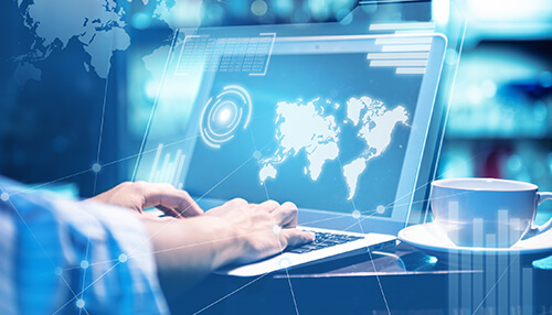 Person working on a laptop with a world map displayed on the screen, symbolizing global business trends and digital connectivity Small business challenges digital adoption