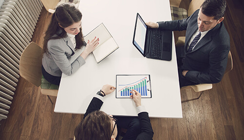 How can coach financing help you Team reviewing financial charts and discussing coach financing plans around a conference table.