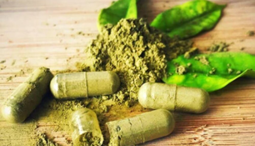 How much yellow kratom should you take to manage symptoms of ptsd Kratom capsules and powder with green leaves, symbolizing the natural herbal supplement used for various health benefits.