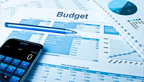 Realistic budget in advance A startup business financing plan with budget sheets, calculator, and financial reports on a workspace.