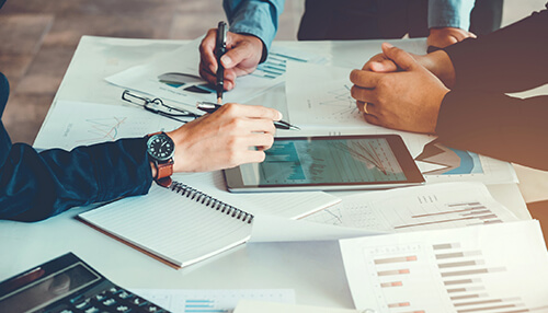 Business plan - tycoonstory | tycoonstory media A business meeting with professionals reviewing financial charts and graphs, along with a tablet, highlighting the need for a comprehensive business plan for success