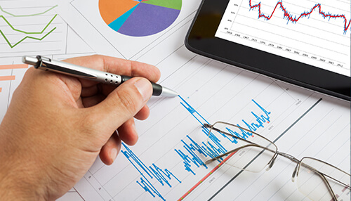 Come up with a comprehensive business strategy - tycoonstory | tycoonstory media Improve your business performance by examining financial graphs, charts, and user interface details on paper templates, using tools like a tablet, pen, and magnifier