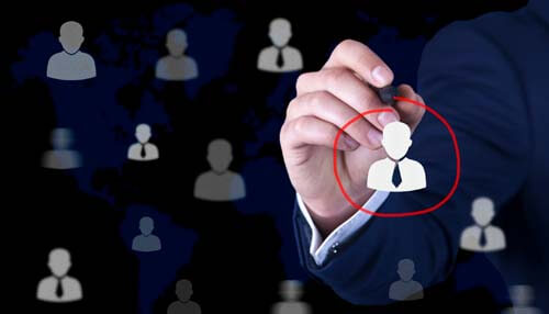 Consider audience segmentation A business professional circles a specific user in a network, symbolizing the focus on a target market in a global context.