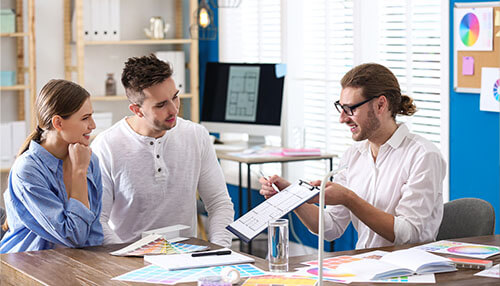 Opening a beauty salon Consultant discussing a business plan with a couple, reviewing design samples and documents for opening a beauty salon.