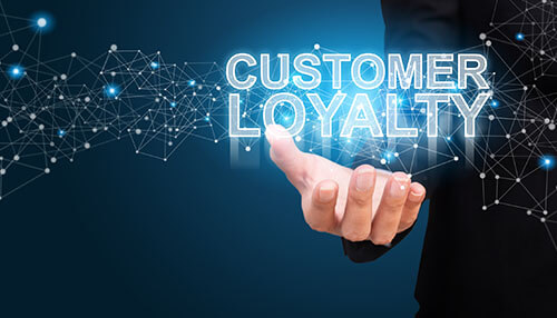 Customer loyalty drives repeat purchases for all businesses - tycoonstory | tycoonstory media Businessperson holding a digital display with the words customer loyalty emphasizing the importance of a customer retention strategy for building loyalty and sustaining business growth.