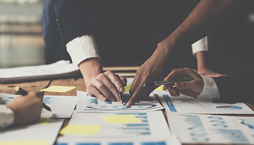 Fund manager and his team of experts A close-up of a laptop screen in a professional home office setting displaying a complex bar chart and performance metrics under the heading "mutual funds. "