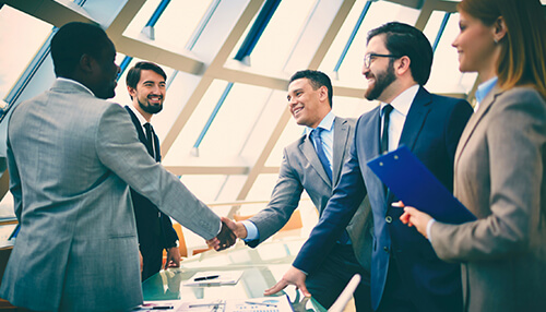 Strategic alliances Business professionals shaking hands in a modern office, representing successful strategic alliances and corporate partnerships.