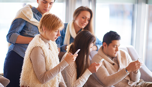 Today there are over 3 billion smartphones in use globally Group of people using smartphones, representing the increasing use of mobile devices for accessing business statistics and data analysis.