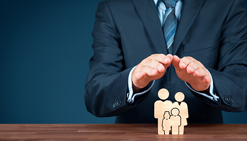 Your insurance coverage and policy - tycoonstory | tycoonstory media Business protection concept with professional shielding wooden family figures symbolizing insurance coverage and financial security.