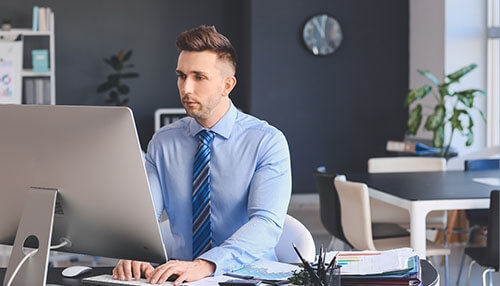 Confident businessman working at his desk in a modern office, building confidence in business increase personal confidence in business