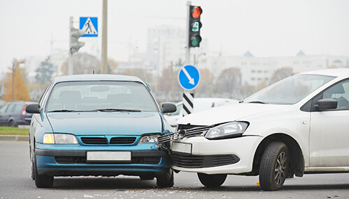 Automobile crash Two vehicles involved in a head-on collision at an intersection, requiring a car accident lawyer.