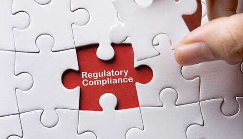 Invest in effective regtech - tycoonstory | tycoonstory media Launching a startup: white puzzle pieces, one red piece in the center displaying the text'Regulatory Compliance,' held by a hand.