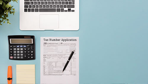 Application for a tax number - tycoonstory | tycoonstory media Application of a tax number with nif portugal, preparation for declaration-laptop, calculator, and stationery on the desk.