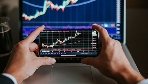 Swing trades - tycoonstory | tycoonstory media A mindful trader analyzes market data and printed reports with a colleague to make strategic investment decisions.