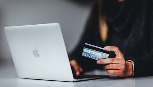 Account is reliable and fast - tycoonstory | tycoonstory media A person using a laptop with a credit card in their hand, to show online business checking accounts and digital financial management.