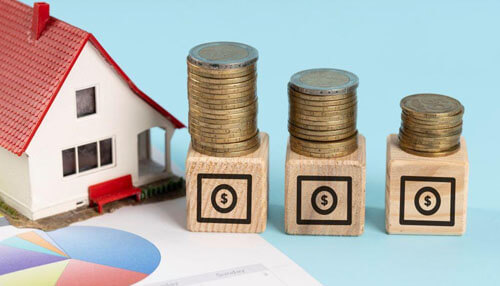 Applying for a mortgage with the help of a broker Stacks of coins beside a model house representing financial planning and approval challenges related to self employed mortgages.