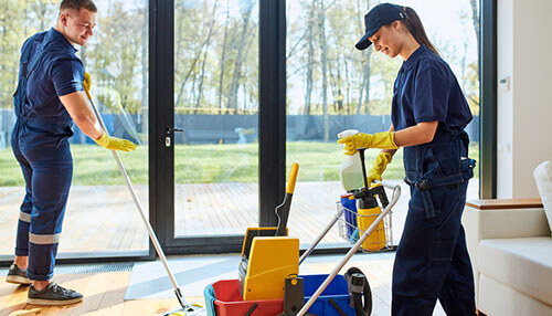 Benefits of routine cleaning Cleaning staff performing floor maintenance with mops and cleaning carts inside a commercial space, demonstrating a routine cleaning inspection to ensure hygiene and compliance with cleanliness standards.