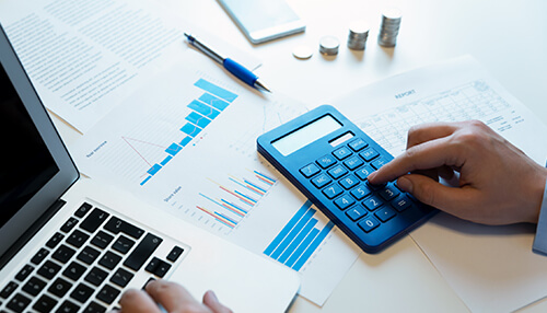 Create and stick to a budget A vibrant green book titled "money management" resting on a desk next to thick stacks of one-hundred-dollar bills, representing the foundational knowledge required for personal and business wealth growth.