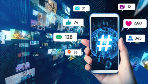 Creating a brand hashtag A hand holding a smartphone displaying the hashtag symbol along with social media metrics, illustrating the importance of creating the best instagram hashtags to boost brand awareness.
