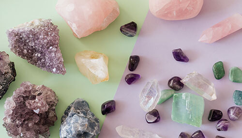 How to find best supplier of crystals and gems A variety of raw crystals and gemstones, including amethyst and rose quartz, arranged in a visually appealing display on contrasting backgrounds.