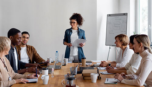 Designate employees as leads Corporate procurement team discussing sourcing strategies and supplier planning during a business meeting.