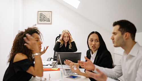 Team conflict Employees having a tense discussion at the workplace, reflecting conflict resolution challenges in office settings.