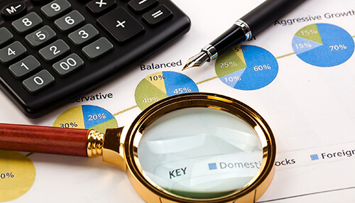 Learn the different accounting methods Accounting skills: close-up of a calculator, pen, and magnifying glass on a financial document, representing analysis and accounting expertise.