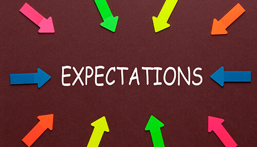 Set clear expectations Colorful arrows surrounding the word'EXPECTATIONS,' reflecting the various expectations a boss has for their team and business outcomes.