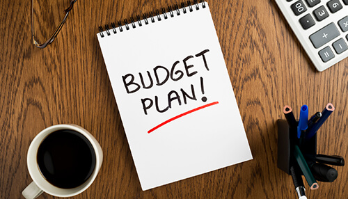 Start adapting yourself to the new budget plan Budget plan notebook on a wooden table symbolizing financial preparation for a career transition.