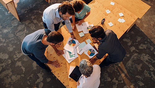 Stay organized Accounting skills: a group of professionals collaborating over financial reports and pie charts, discussing accounting strategies in a team setting.