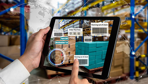 Tool management system A hand holding a tablet displaying a warehouse tracking system, highlighting stock levels and order status to efficiently track goods.